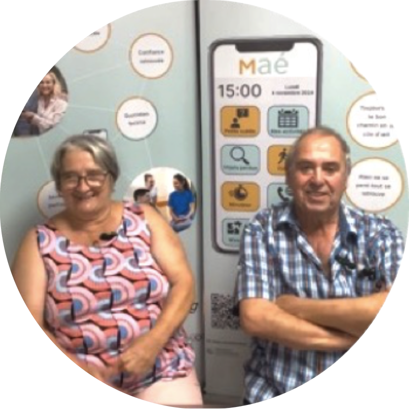 Photo de Jacky et Chantal devant une affiche Maé®, des personne qui on essayer Maé® lors des expérimentation.