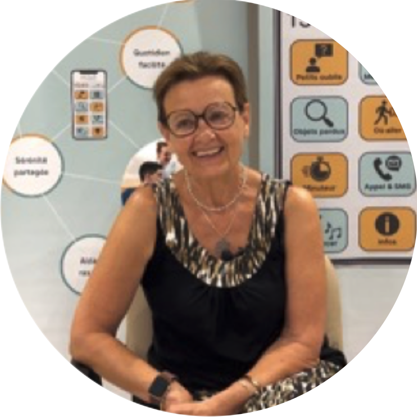 Photo de Françoise devant une affiche Maé®, elle a essayer Maé® lors des expérimentation.